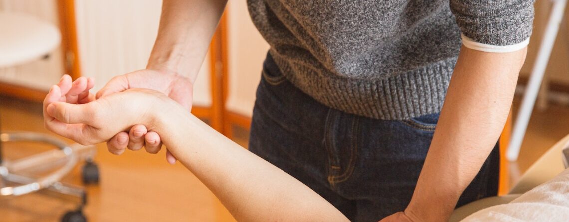 Chiropractor Massaging Hand of Patient