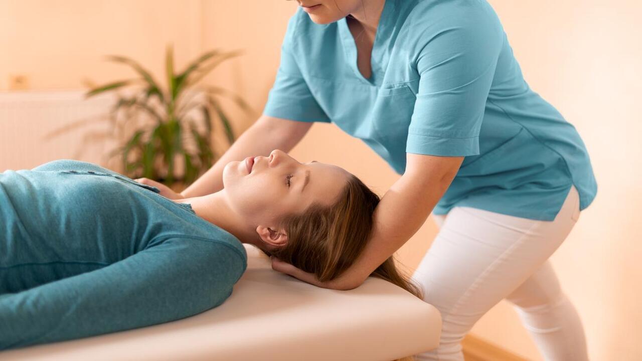Female Chiropractor Adjusting the Patient's Neck