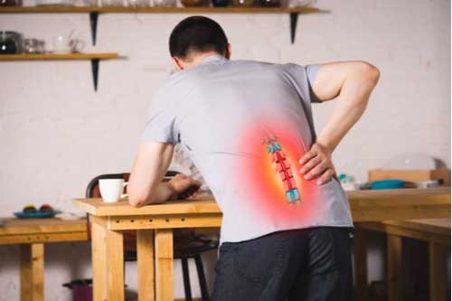 Man rubbing hurt back, Cape Coral back injury treatment concept